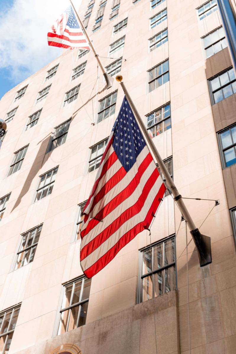 A US flag outside a stone government building