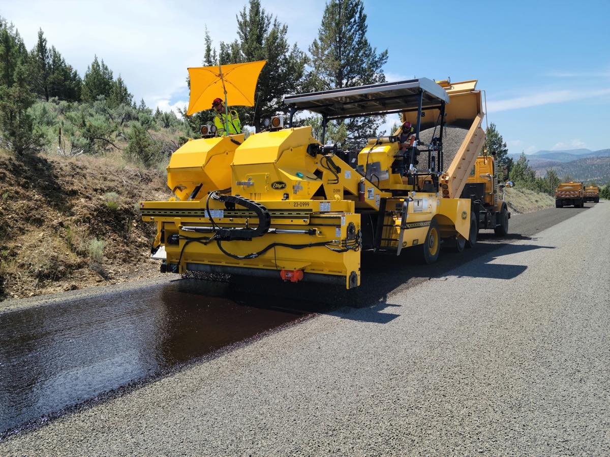 A paver laying fresh asphalt on a rural road, the kind of road work that leads Ohio's state and local bids